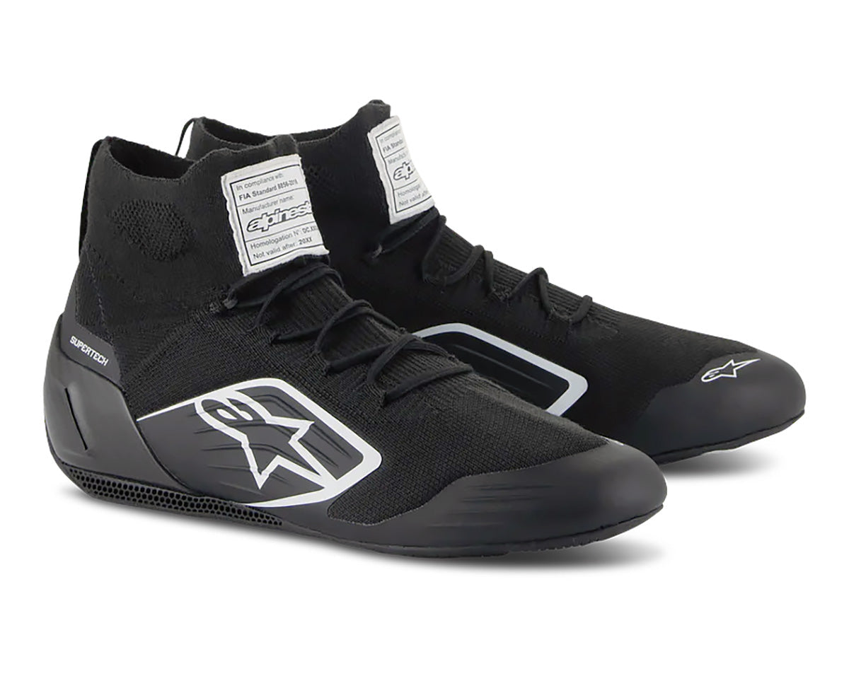 A pair of Alpinestars Supertech high-top racing shoes in black color, featuring a knitted upper, carbon heel cup, and a 3D printed midsole.